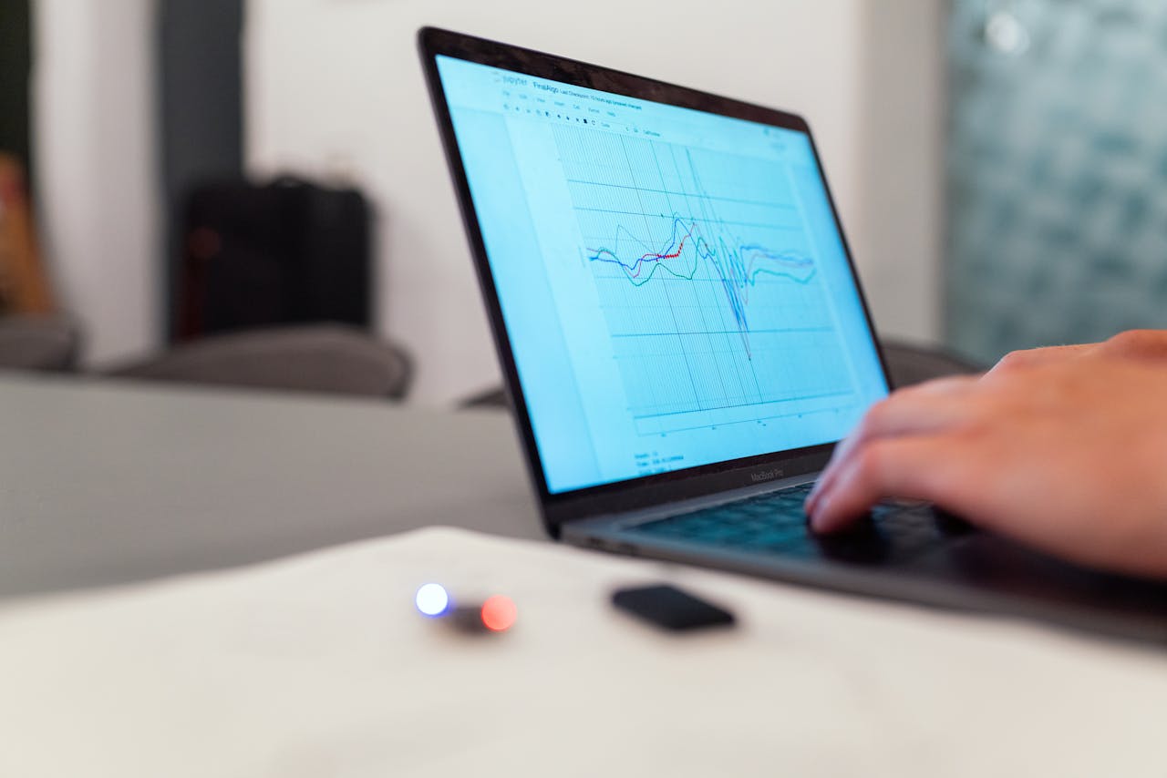 A laptop showing an analytics graph while being typed on.